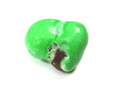 Green double nut. Left side is fairly pristine, but cracky and crumbly in the middle and large worn-off brown bit on the bottom-right.