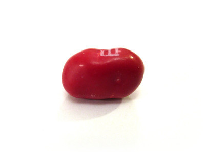 A deformed red candy, wider than it is tall.