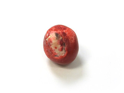 Nut bespeckled with crumbly red bits, poking through.