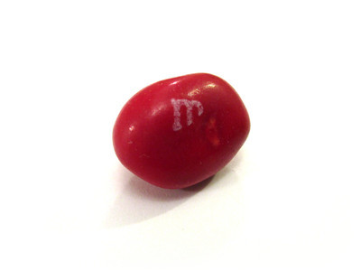 A red nut, not too strange looking, but with a divot/dimple and a diagonal chunk removed from the "m".